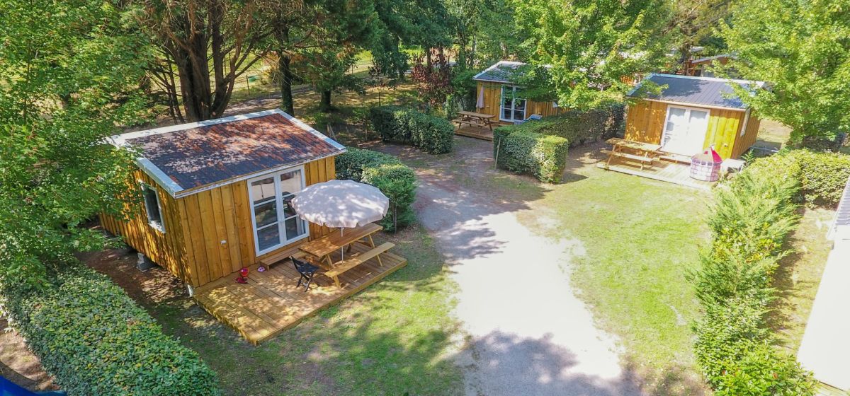 Hébergements en bois sous les arbres au camping Landes Azur